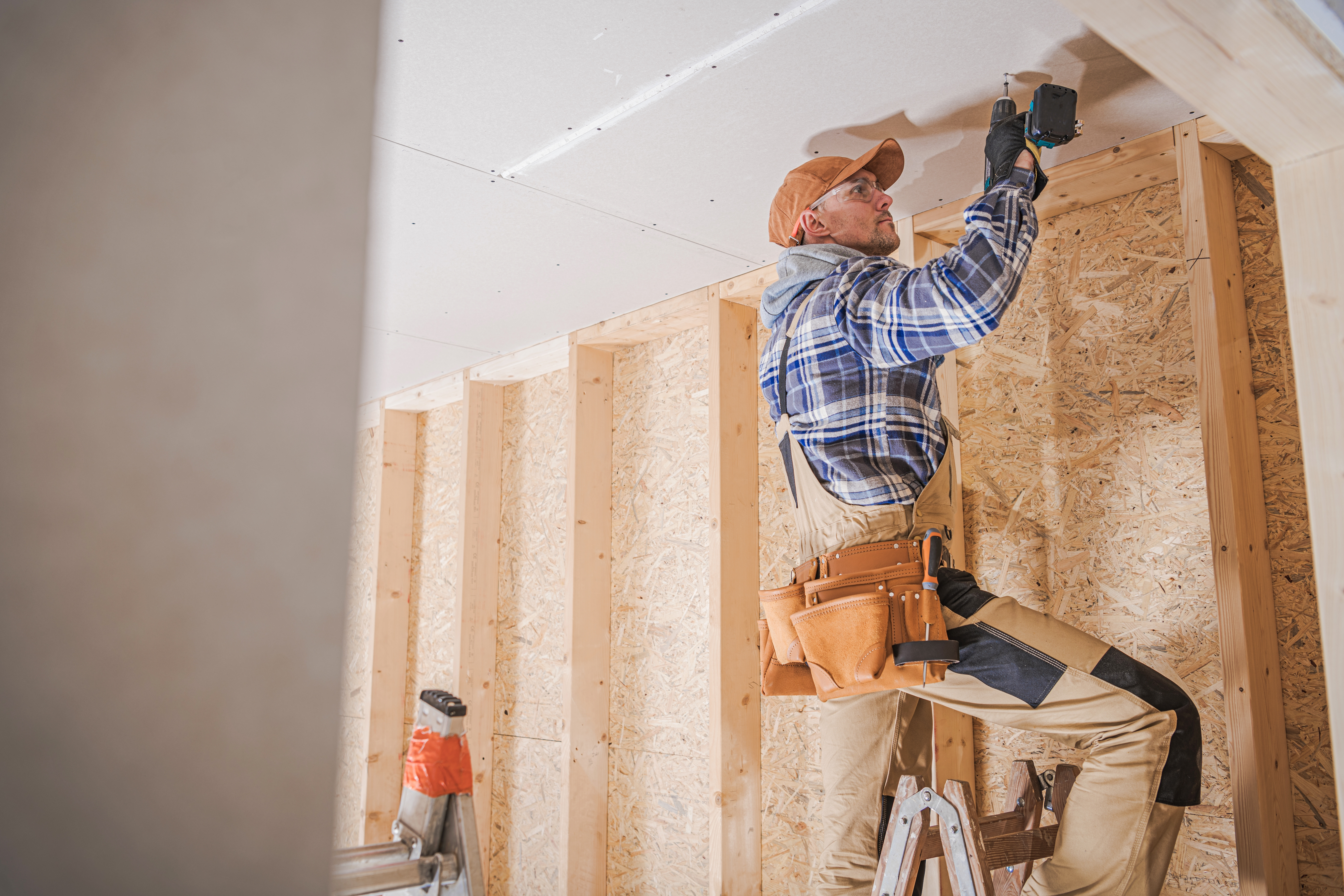 Carpenter installing drywall overhead