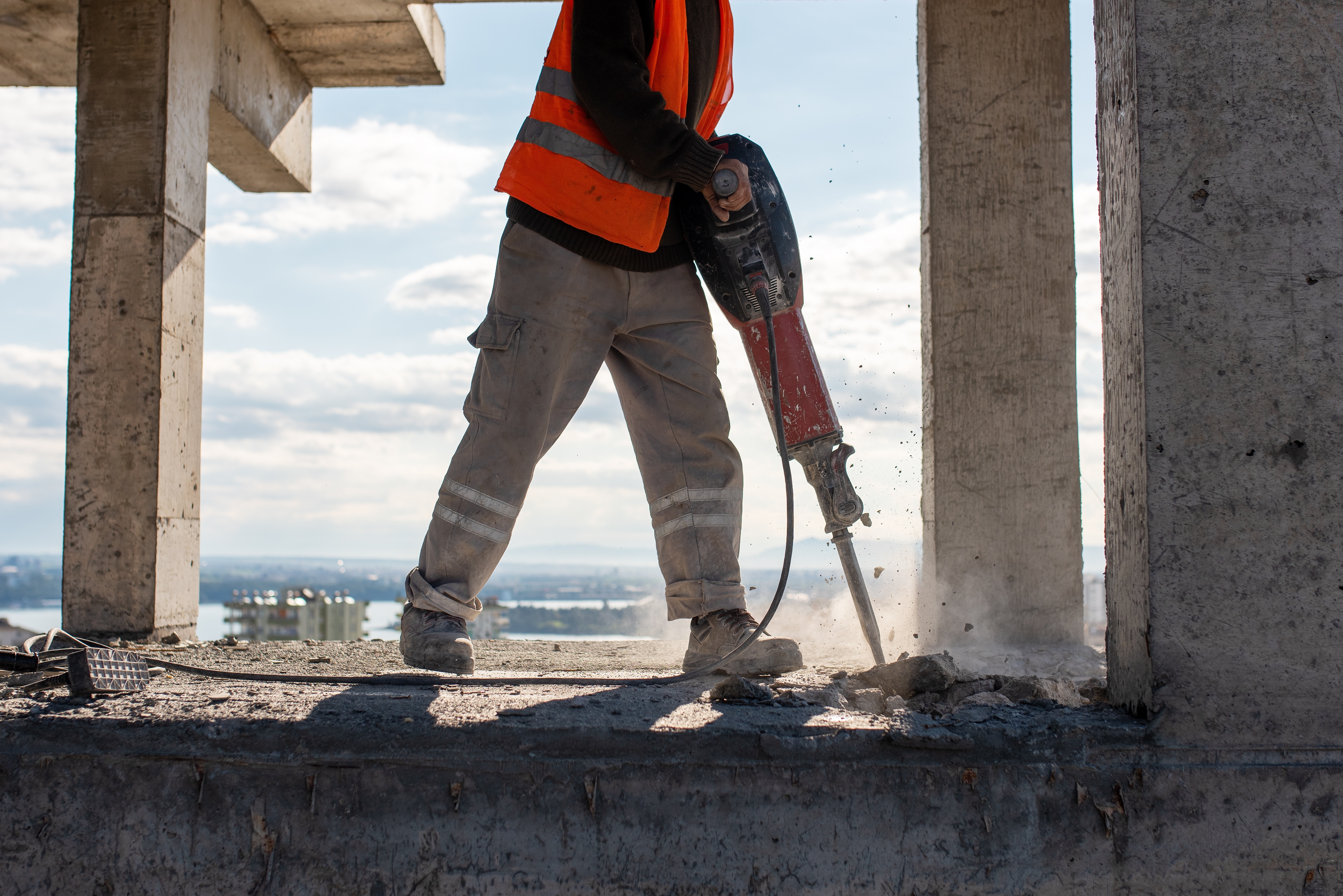 Worker using jackhammer on concrete